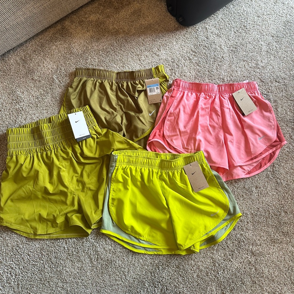 4 pairs of new with tags Nike running shorts size Medium. Pink and green.